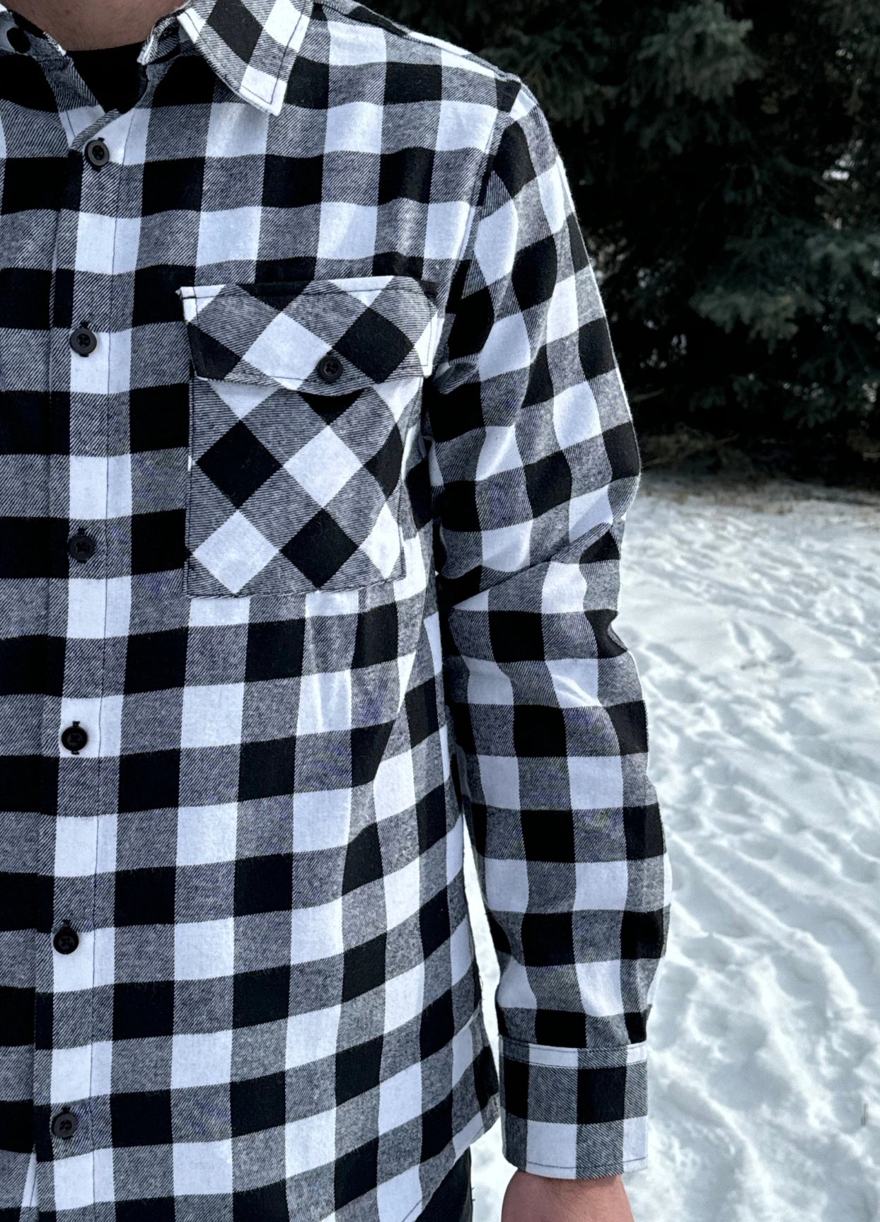 Classic Black and White Buffalo Check Shirt taken outside in the snow in Banff, Canada. The shirt has 2 front pockets and is fitted.