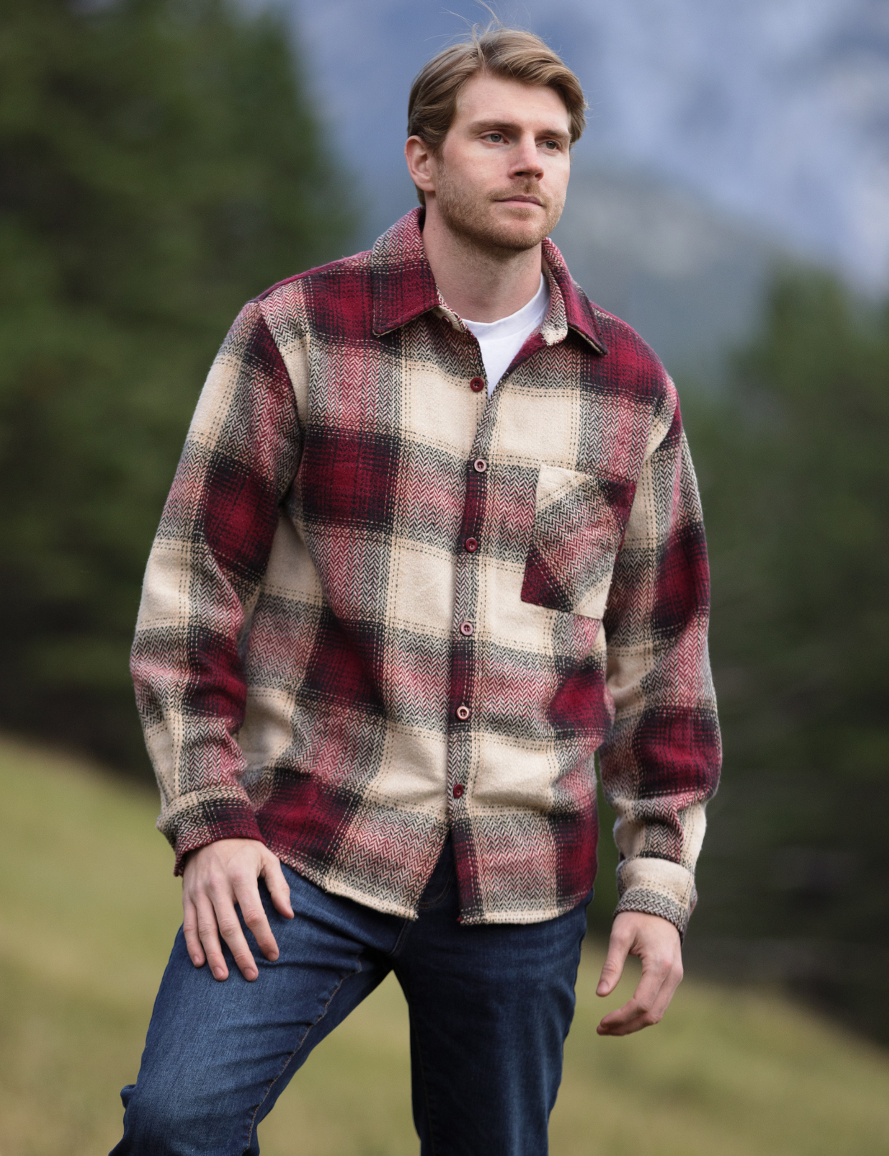 A person wearing a long-sleeved burgundy and beige plaid flannel shacket with a single breast pocket, button cuff, and V-silhouette.