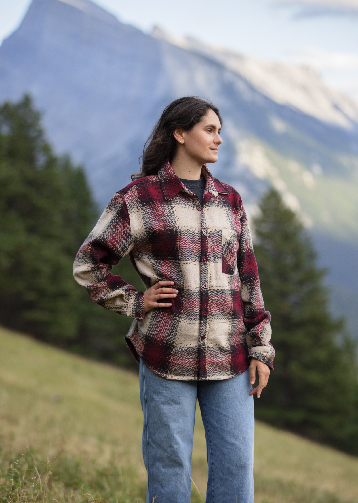 A women stood in a field with mountains in the background