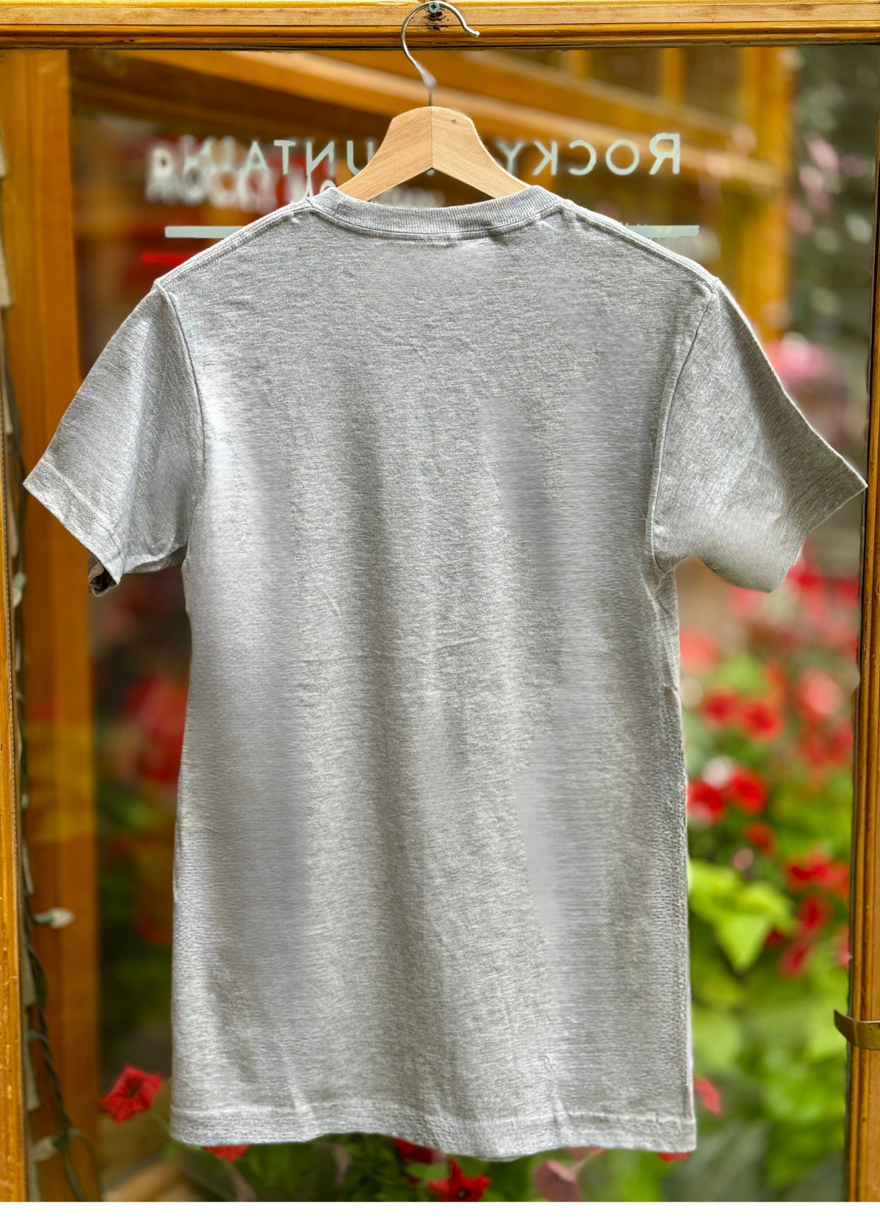 Grey t-shirt on a hanger with a blurred background