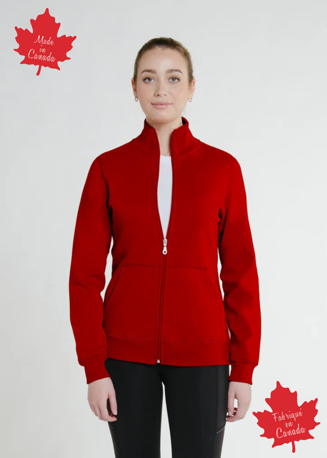 A woman wearing a full zip fitted Canadian jacket in red with a Canadian flag patch on the left sleeve and a flat-lock stitching detail.