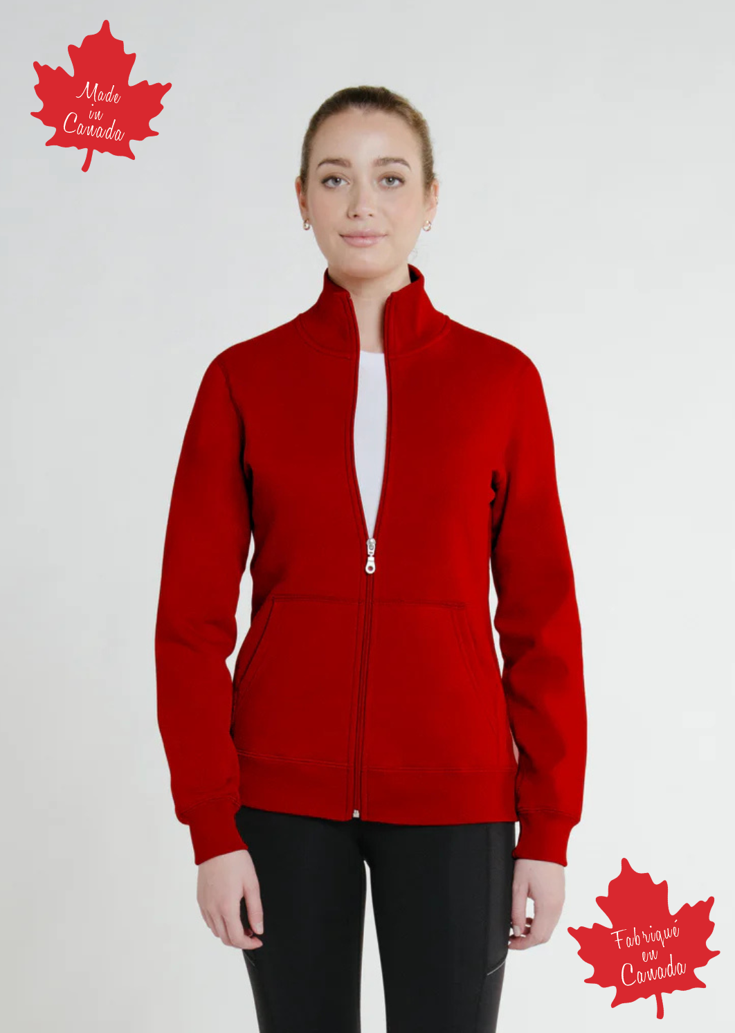 A woman wearing a full zip fitted Canadian jacket in red with a Canadian flag patch on the left sleeve and a flat-lock stitching detail.