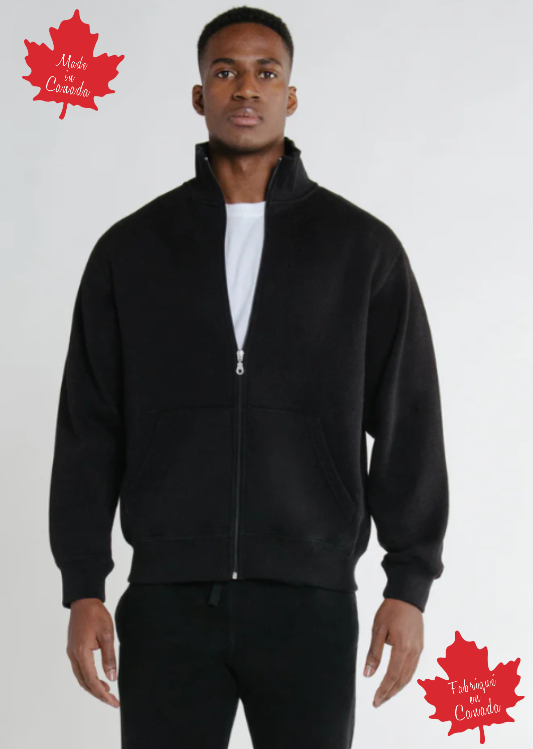 A man wearing a full zip black relaxed fit Canadian jacket with a soft stand collar and Canadian flag patch on the left sleeve.