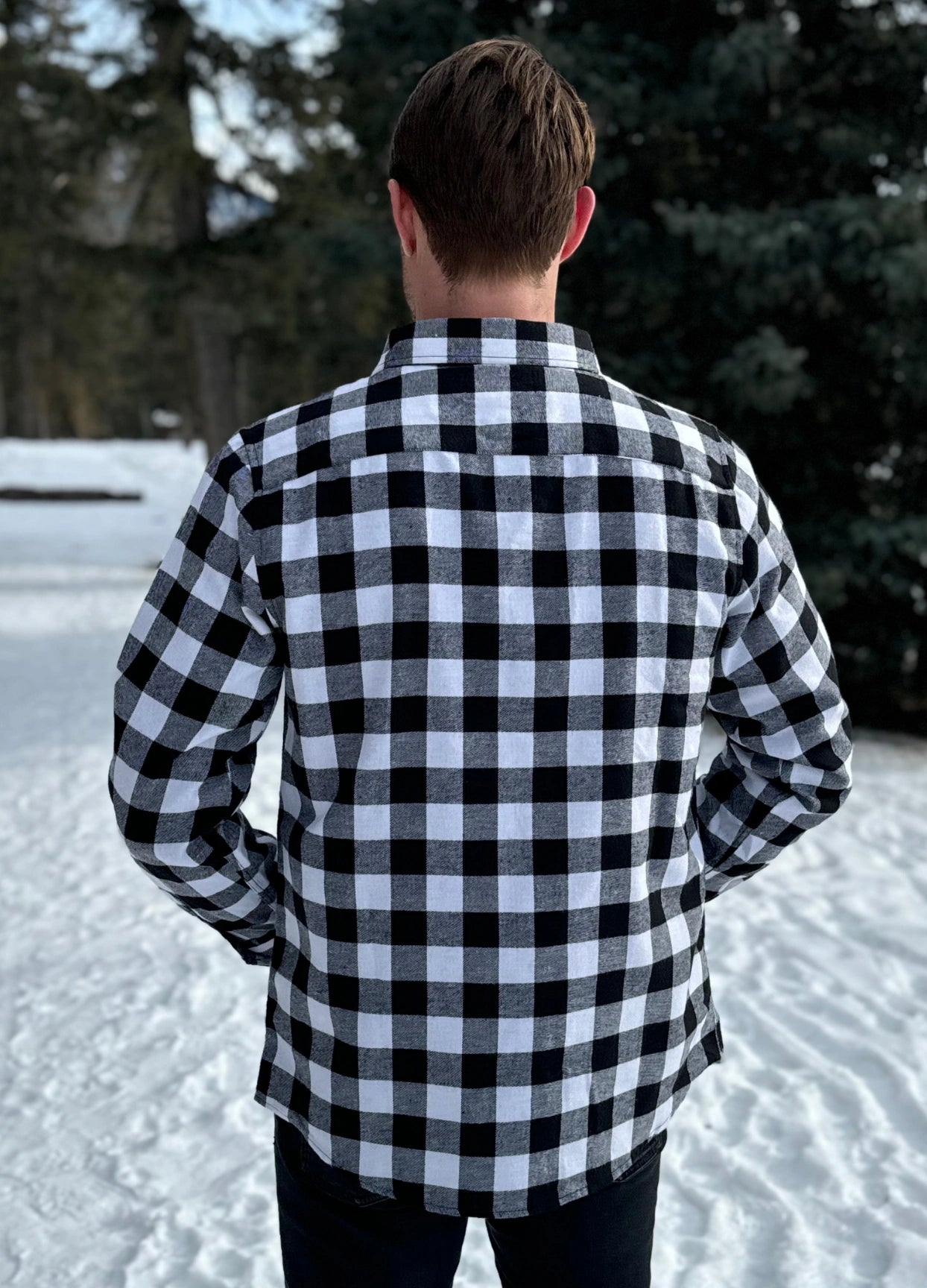 Back view of Classic Black and White Buffalo Check Shirt taken outside in the snow in Banff, Canada. The shirt has 2 front pockets and is fitted.