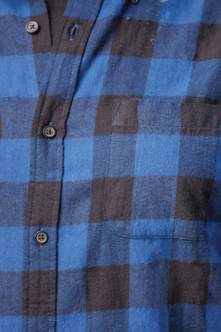 Close up of long-sleeved marine blue and black buffalo check flannel shirt.