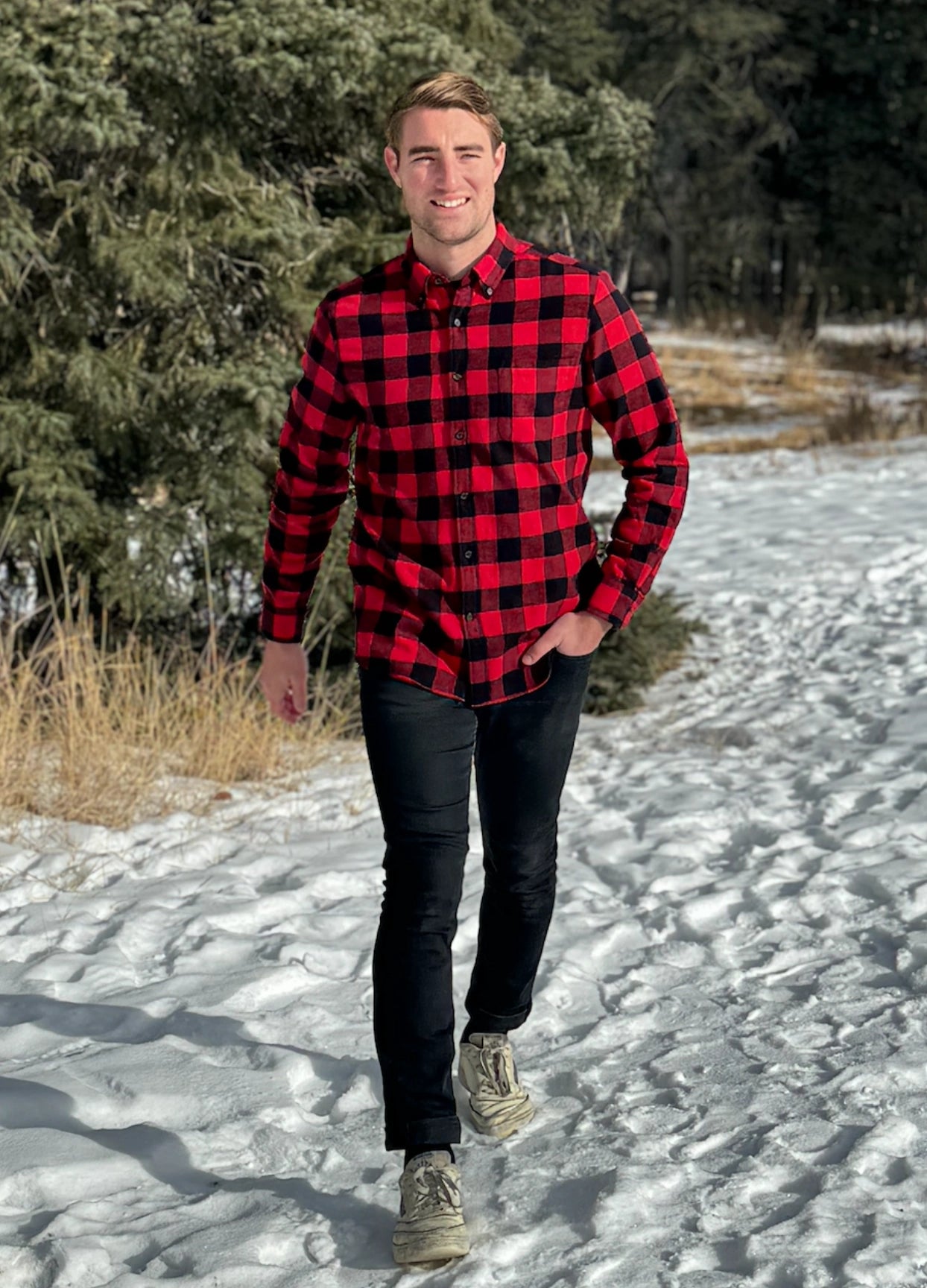 A man wearing a classic Canadian red and black buffalo check button-down shirt with a single pocket on the chest.