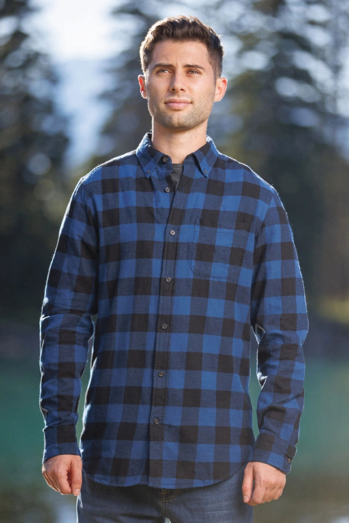 Man standing outdoors wearing long-sleeved marine blue and black buffalo check flannel shirt.