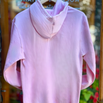 Pink hoodie on a hanger against a blurred background