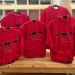Red kids hoodies with a logo and 'Banff Canada' text on a wooden table. Showing the various kids sizes.