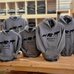 Kids grey hoodies with 'Banff Canada' text and bear designs on a wooden table.