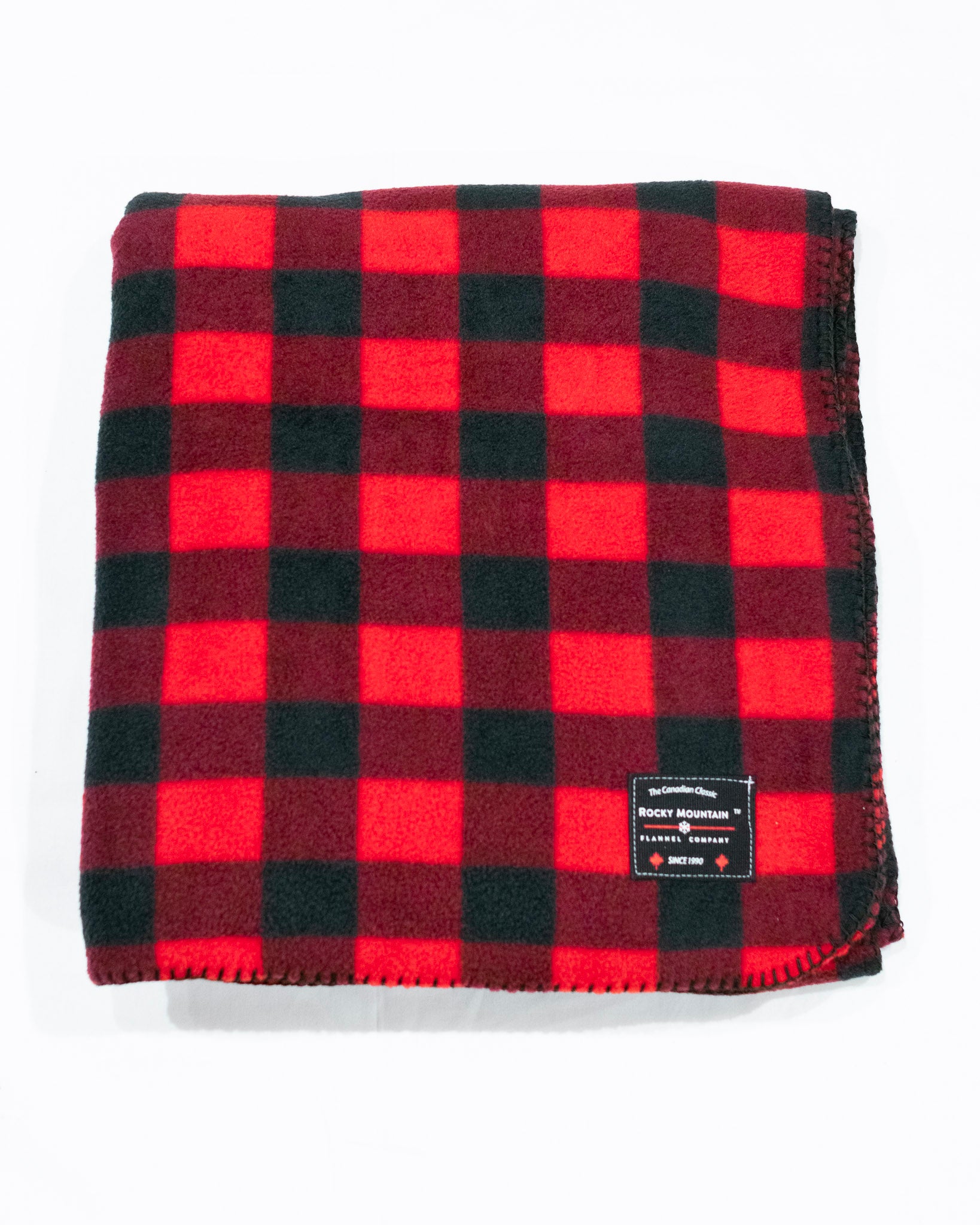A red and black buffalo check fleece blanket with a label showing the brand name.
