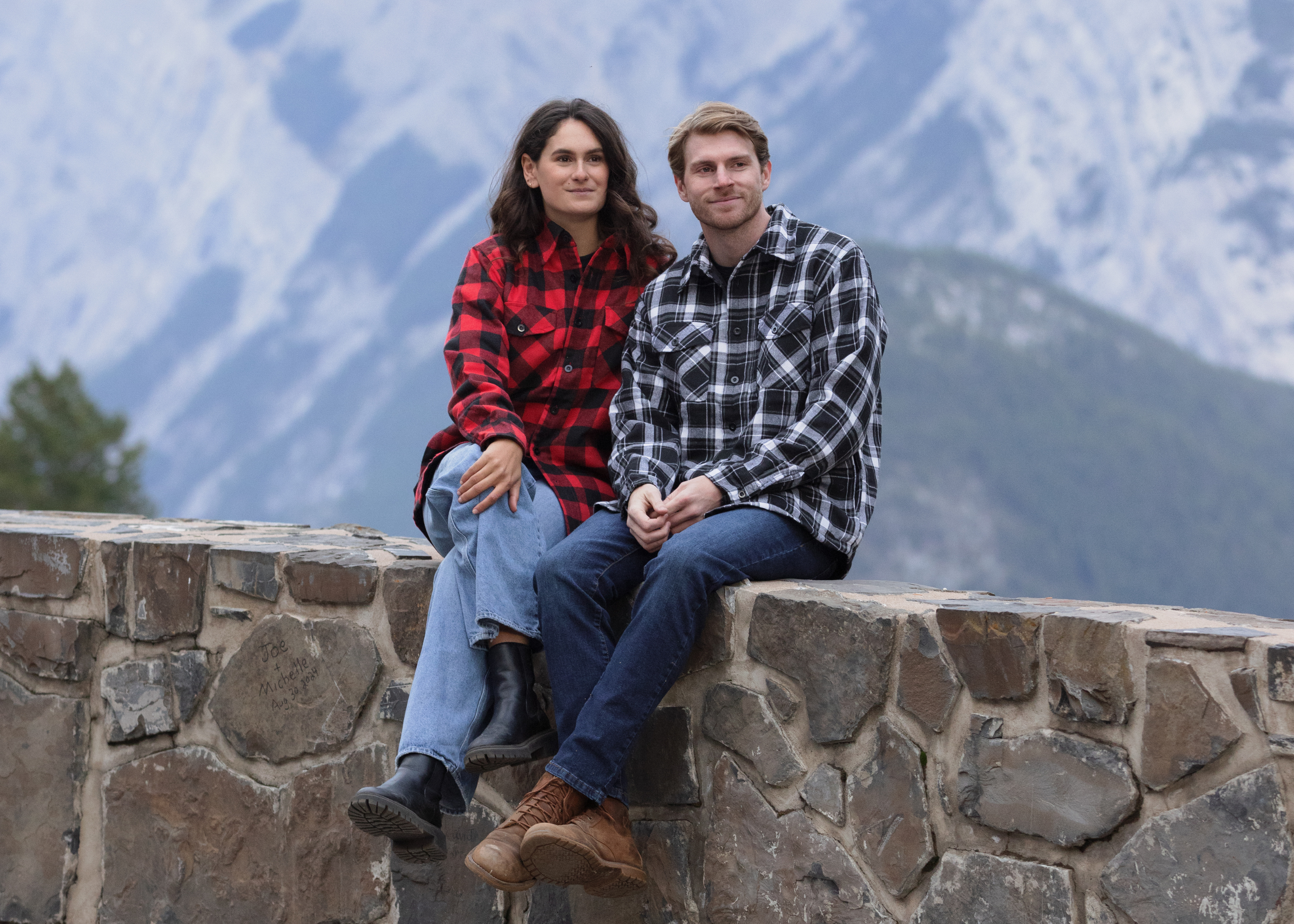 A couple sat on a wall in Banff National Park