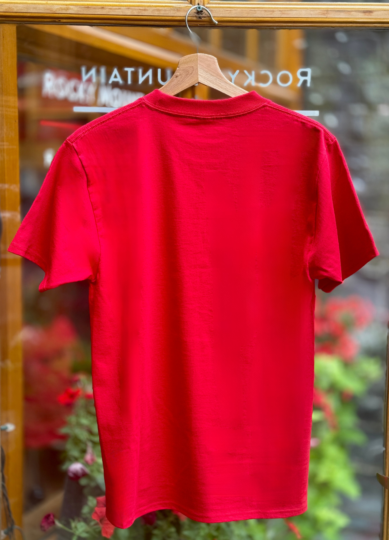 Red t-shirt on a hanger with a blurred background