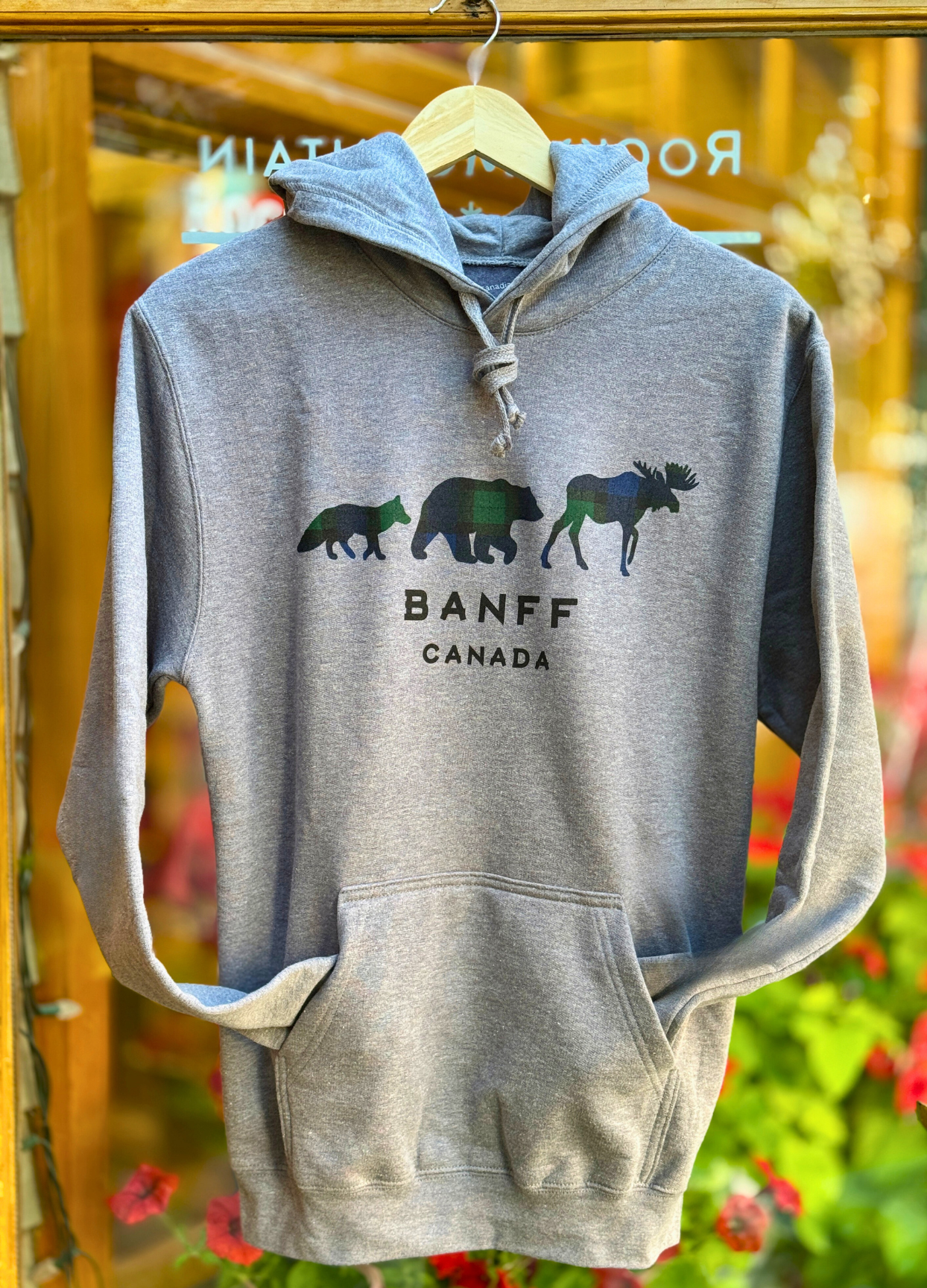 Grey hoodie with 3 Canadian Animals design and 'Banff Canada' text on a hanger.
