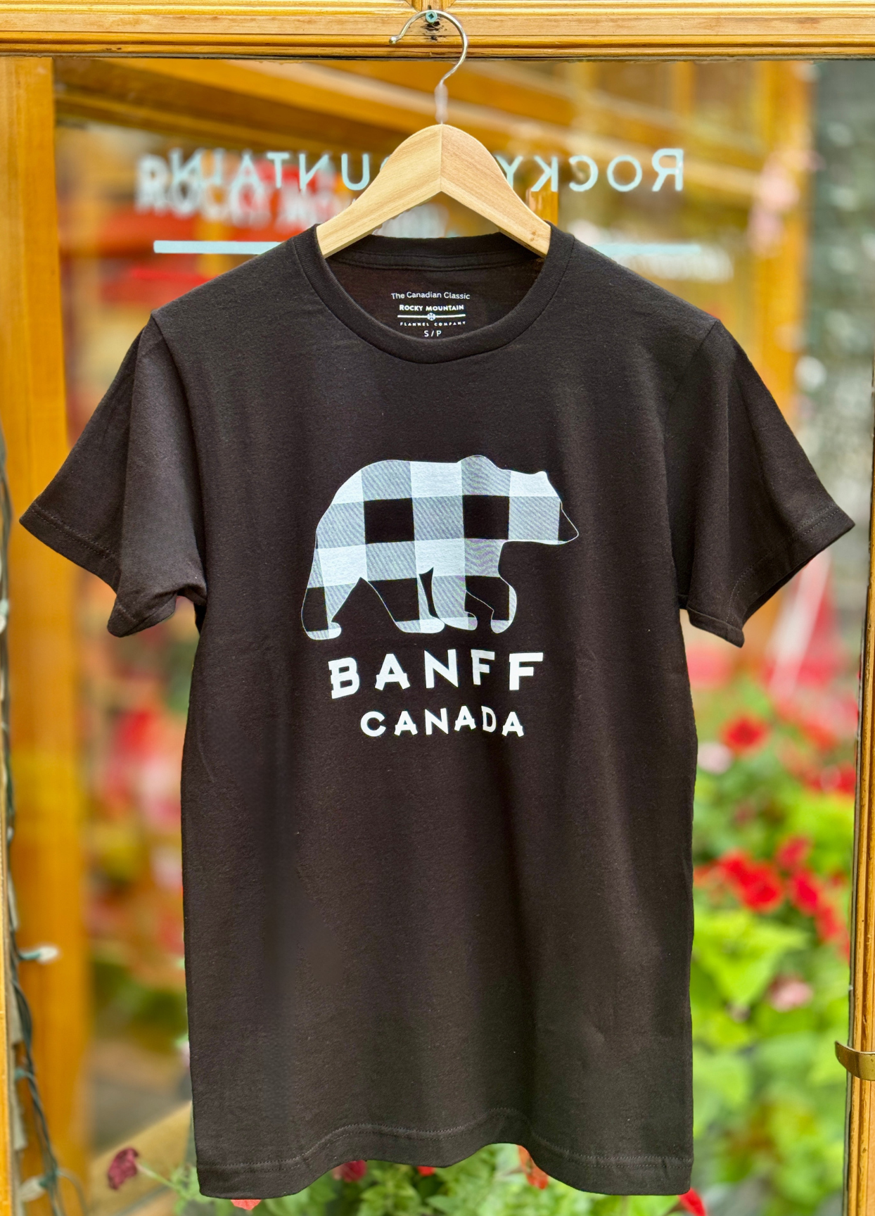 Black t-shirt with a bear graphic and 'Banff Canada' text on a hanger.