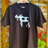 Black t-shirt with a white moose graphic on a hanger in front of a store window.
