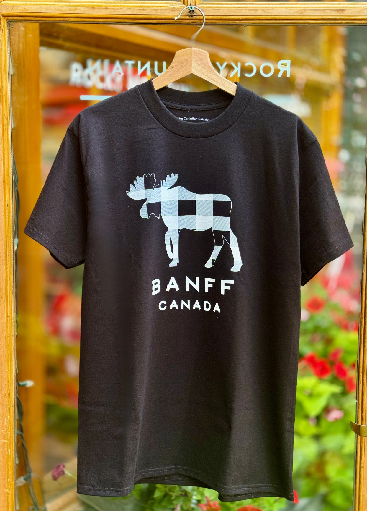 Black t-shirt with moose graphic and 'Banff Canada' text on a hanger.