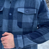 Close up of buttons on the cuff and front left pocket of the Brush Flannel Shacket / Navy & Blue Large Buffalo Check