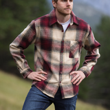 Man stood in field with hands on hip, modeling our burgundy wool jacket 