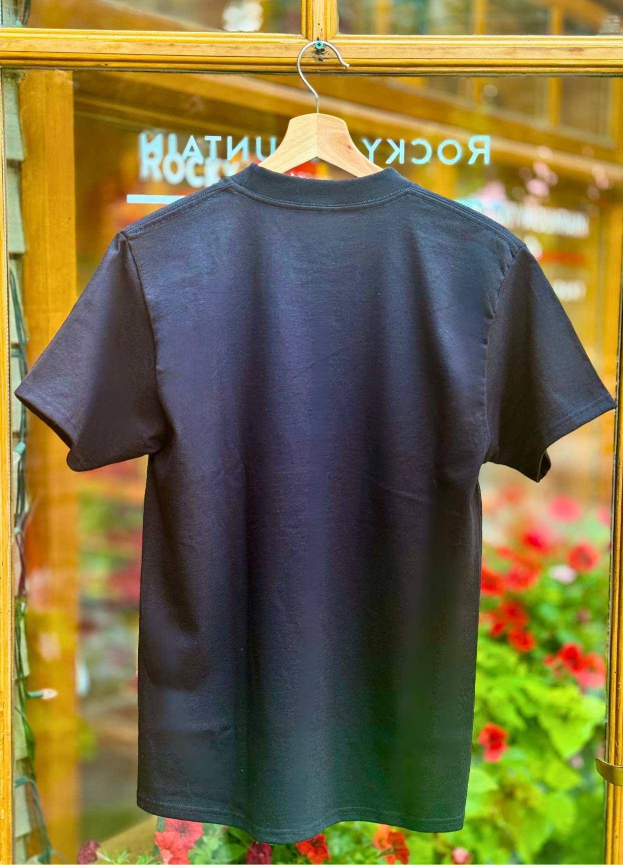 Black t-shirt on a hanger with a blurred background