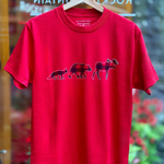 Red t-shirt with bear family graphic on a hanger in front of a store window.