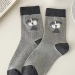 Gray socks with dog design on a light surface