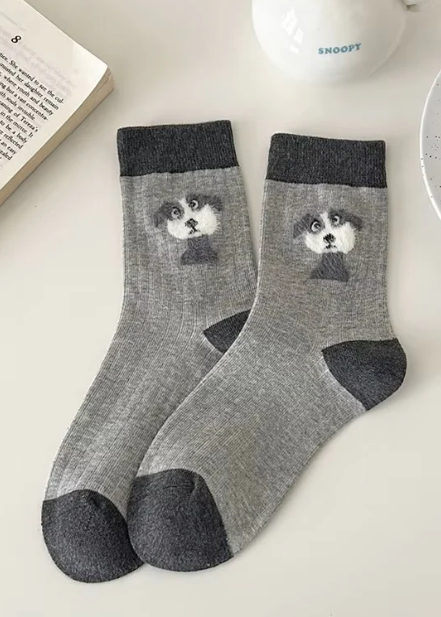Gray socks with dog design on a light surface
