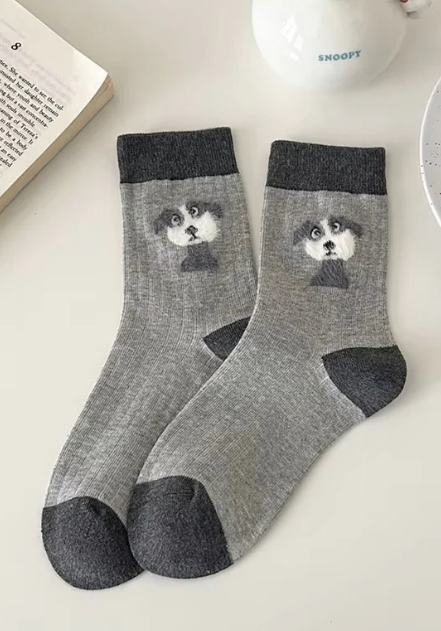 Gray socks with dog design on a light surface