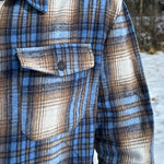 Close up of breast of jacket with a pocket and black button.