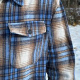Close up of breast of jacket with a pocket and black button.