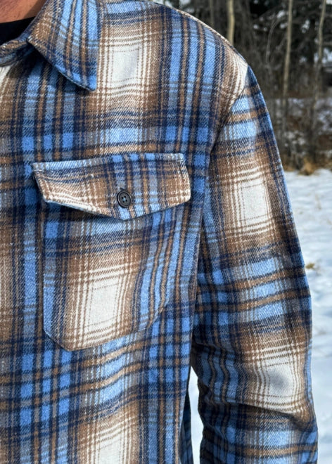 Close up of breast of jacket with a pocket and black button.