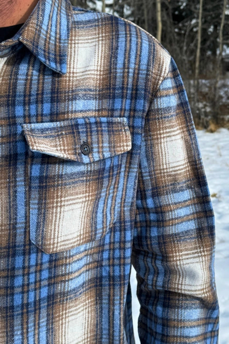 Close up of breast of jacket with a pocket and black button.