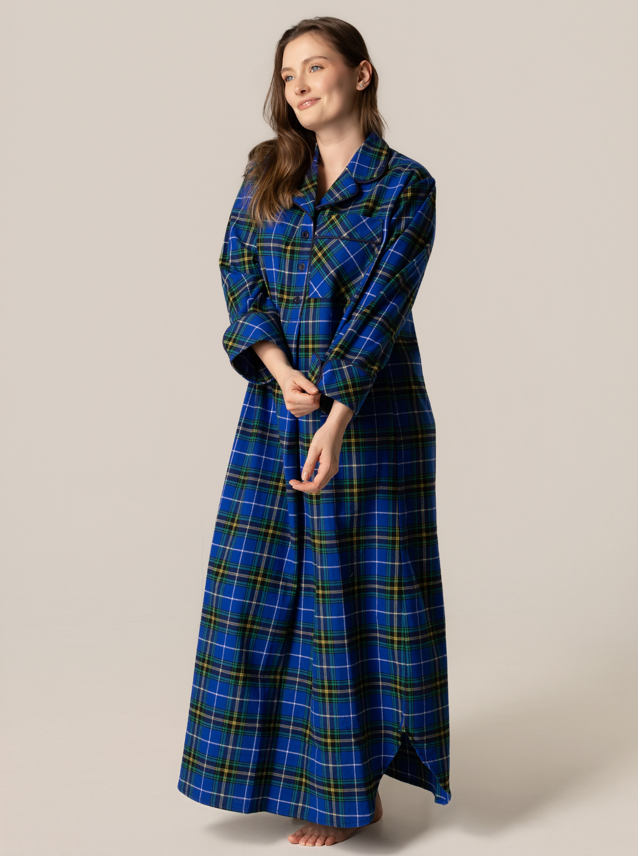 Woman wearing a blue and green plaid nightshirt against a beige background
