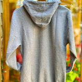 Grey hoodie with a hood on a hanger against a blurred background