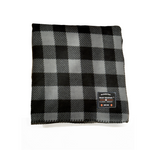 Black and gray checkered blanket with a brand label on a white background
