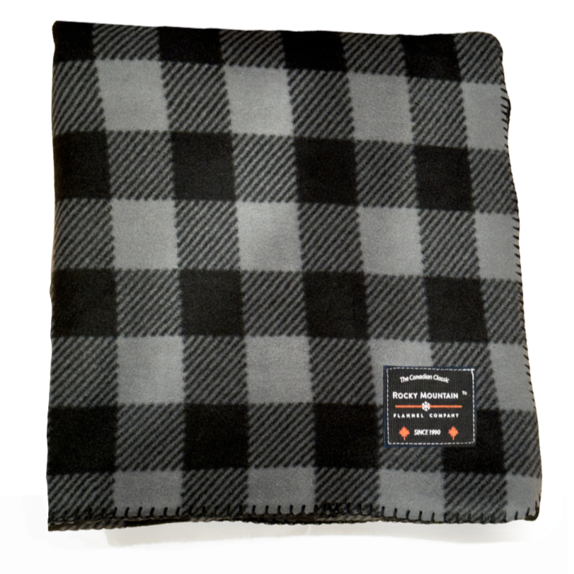 Black and gray checkered blanket with a brand label on a white background