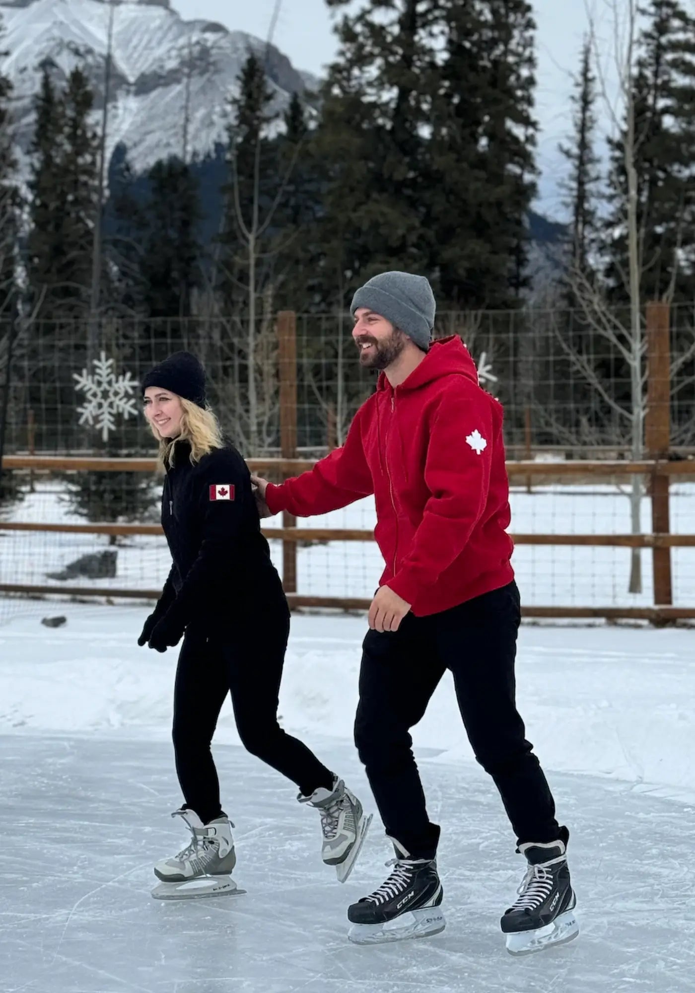 Couple ice skating wearing our Made in Canada Hoodies