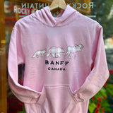 Kids Baby pink hoodie with animal graphics and 'Banff Canada' text on a hanger.