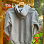 Kids grey hoodie on a hanger with a blurred background of flowers and glass