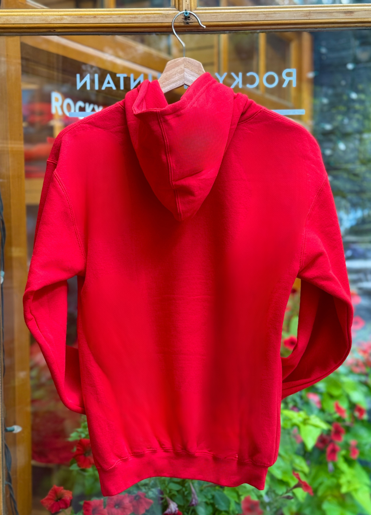 Red hoodie on a hanger with a blurred background