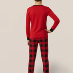 Kid wearing red long-sleeve top and black and red plaid pants on a beige background