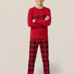 Child wearing red and black plaid pajamas on a beige background