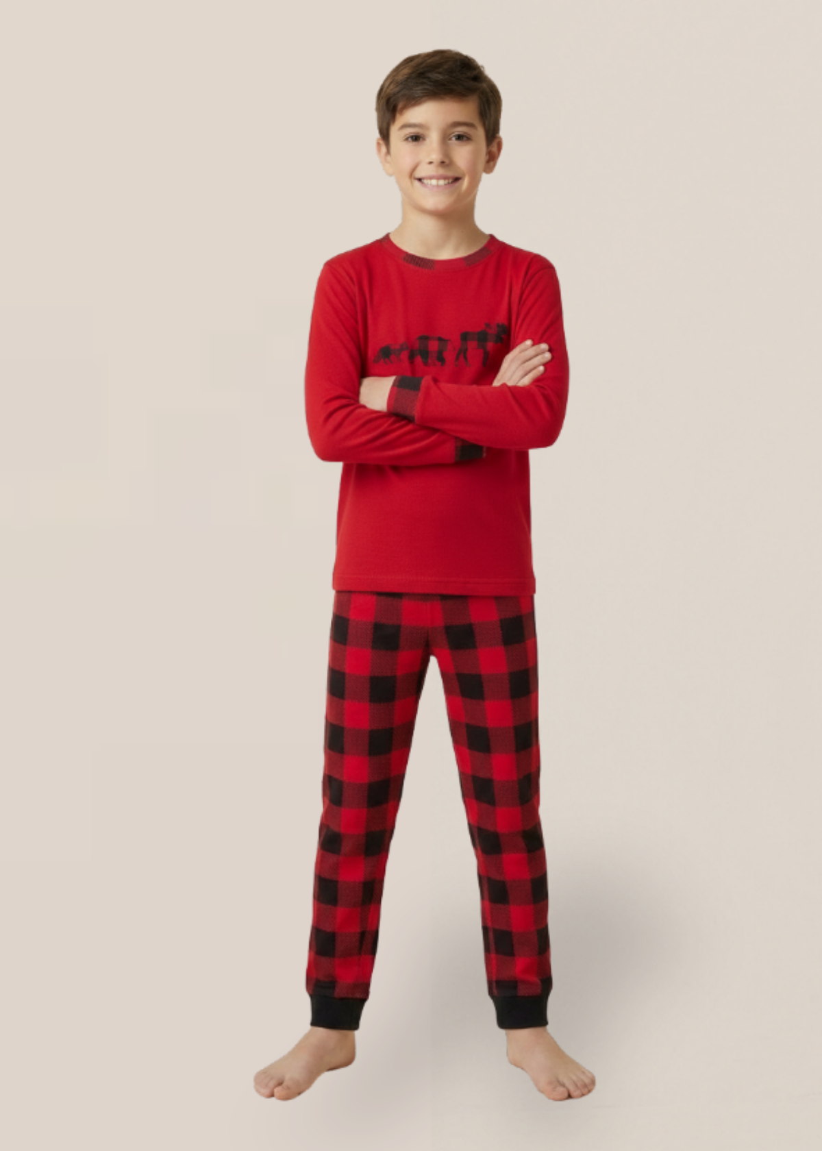 Child wearing red and black plaid pajamas on a beige background