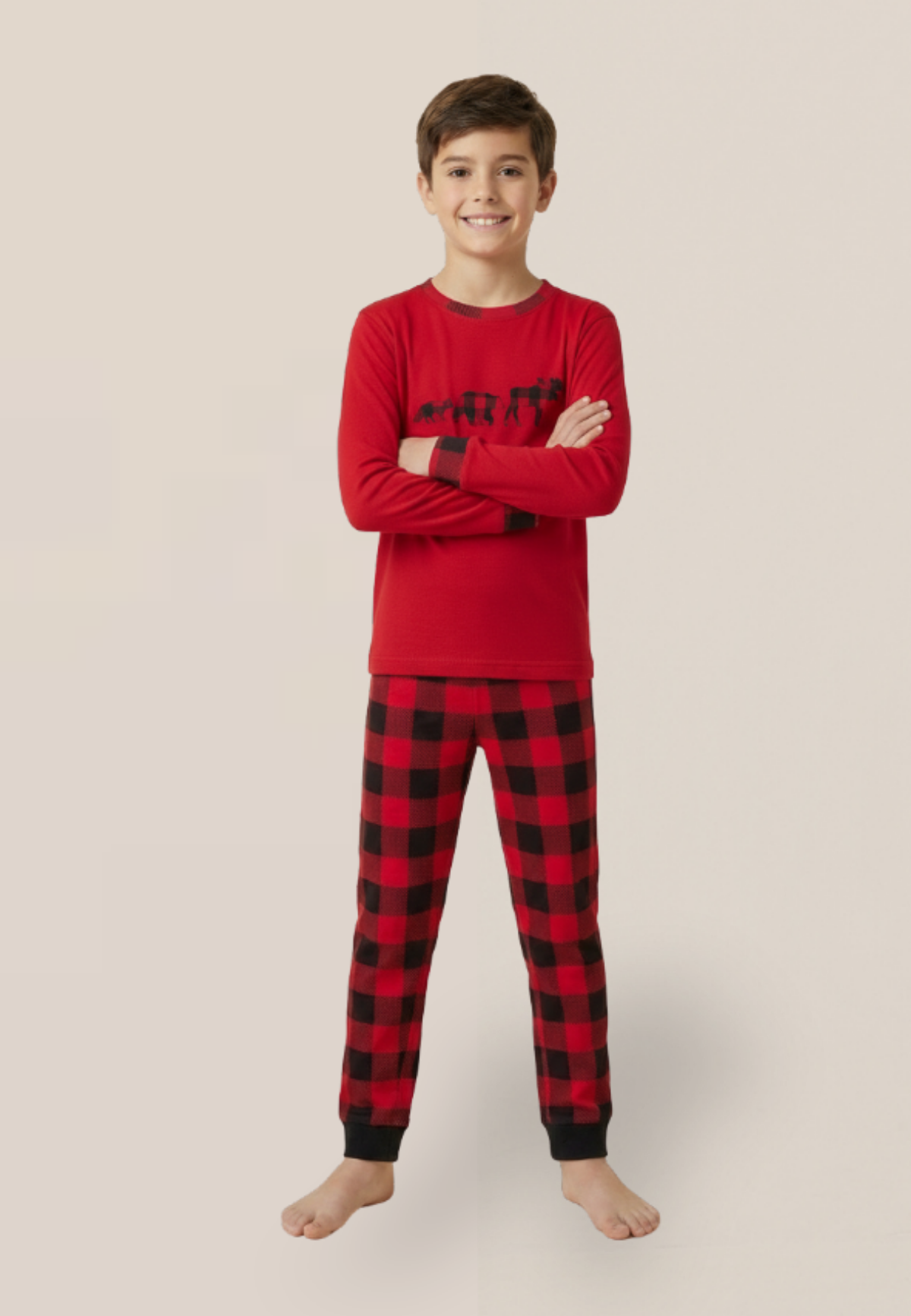 Child wearing red and black plaid pajamas on a beige background