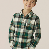 Child wearing a green plaid shirt against a beige background