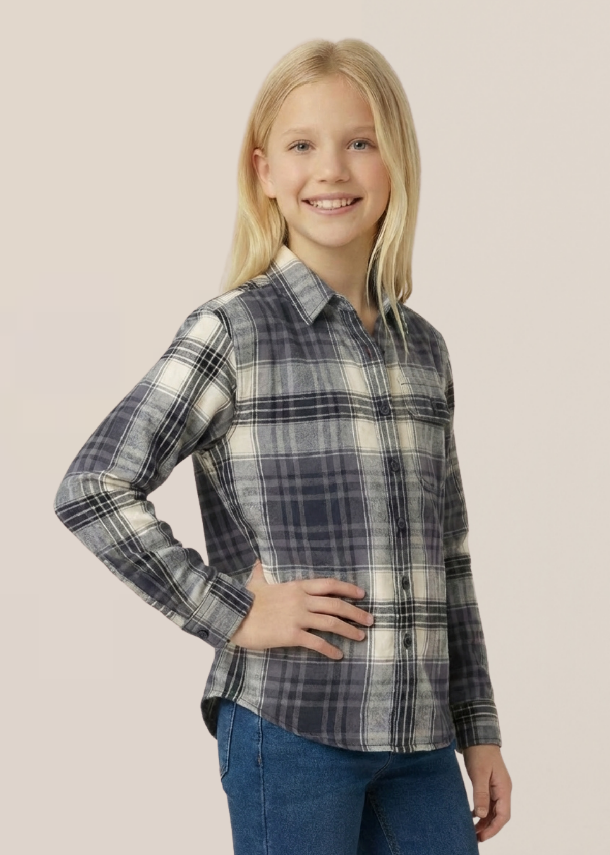 Young girl wearing a plaid shirt and jeans on a beige background
