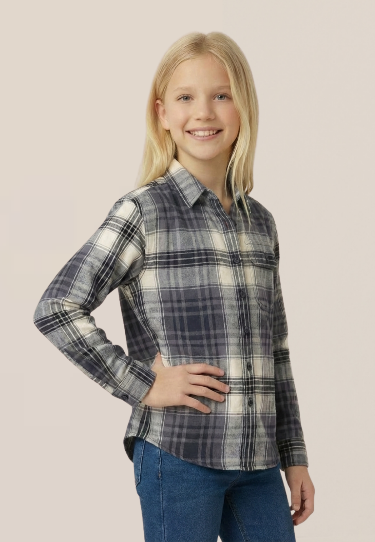 Young girl wearing a plaid shirt and jeans on a beige background