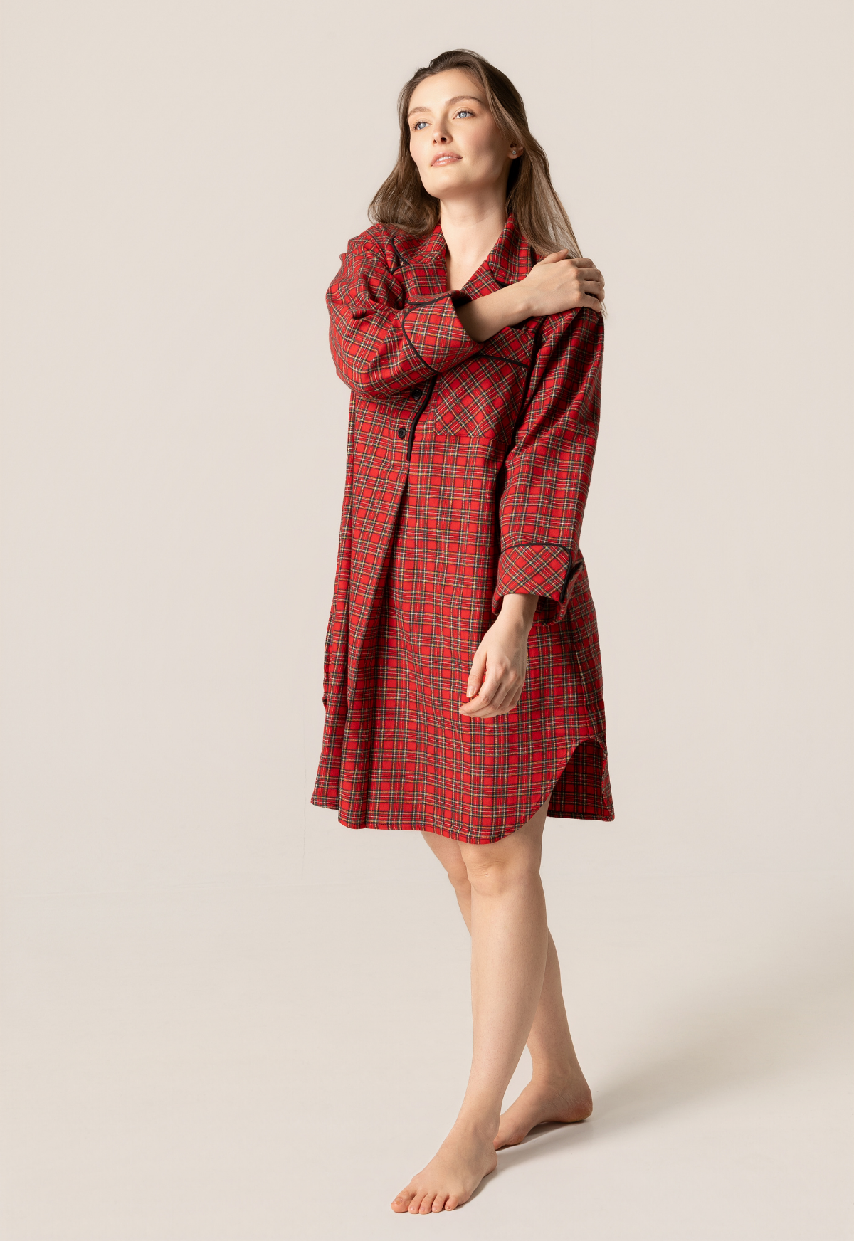 Woman wearing a red plaid nightshirt against a beige background