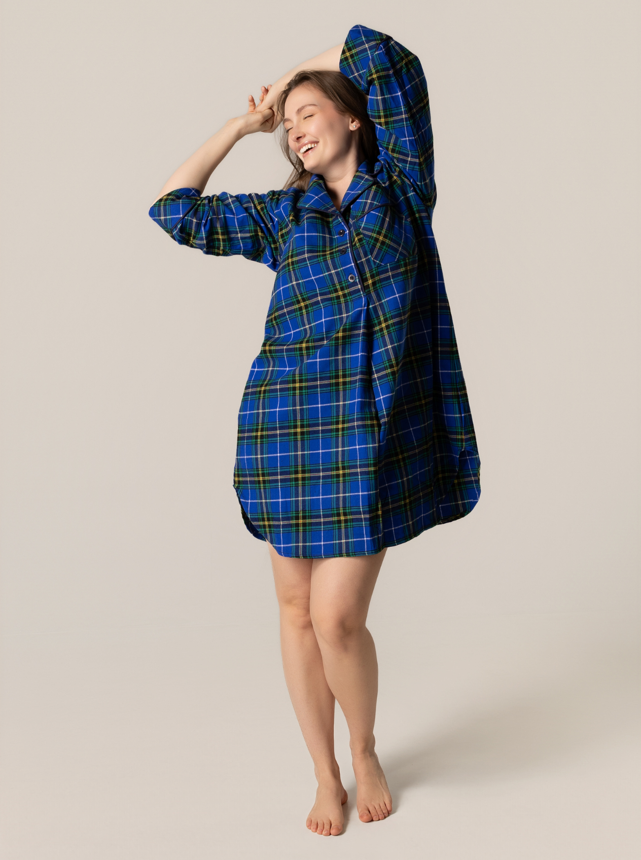 Person wearing a blue plaid nightshirt against a beige background