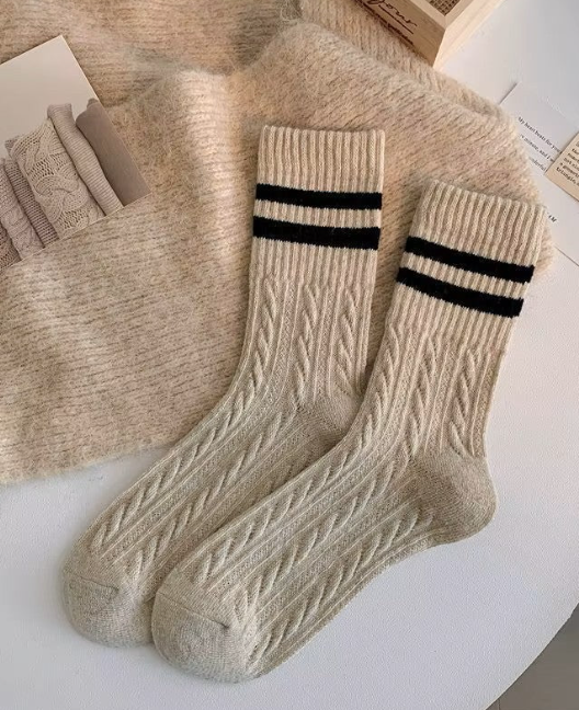 Beige wool socks with black stripes on a light background